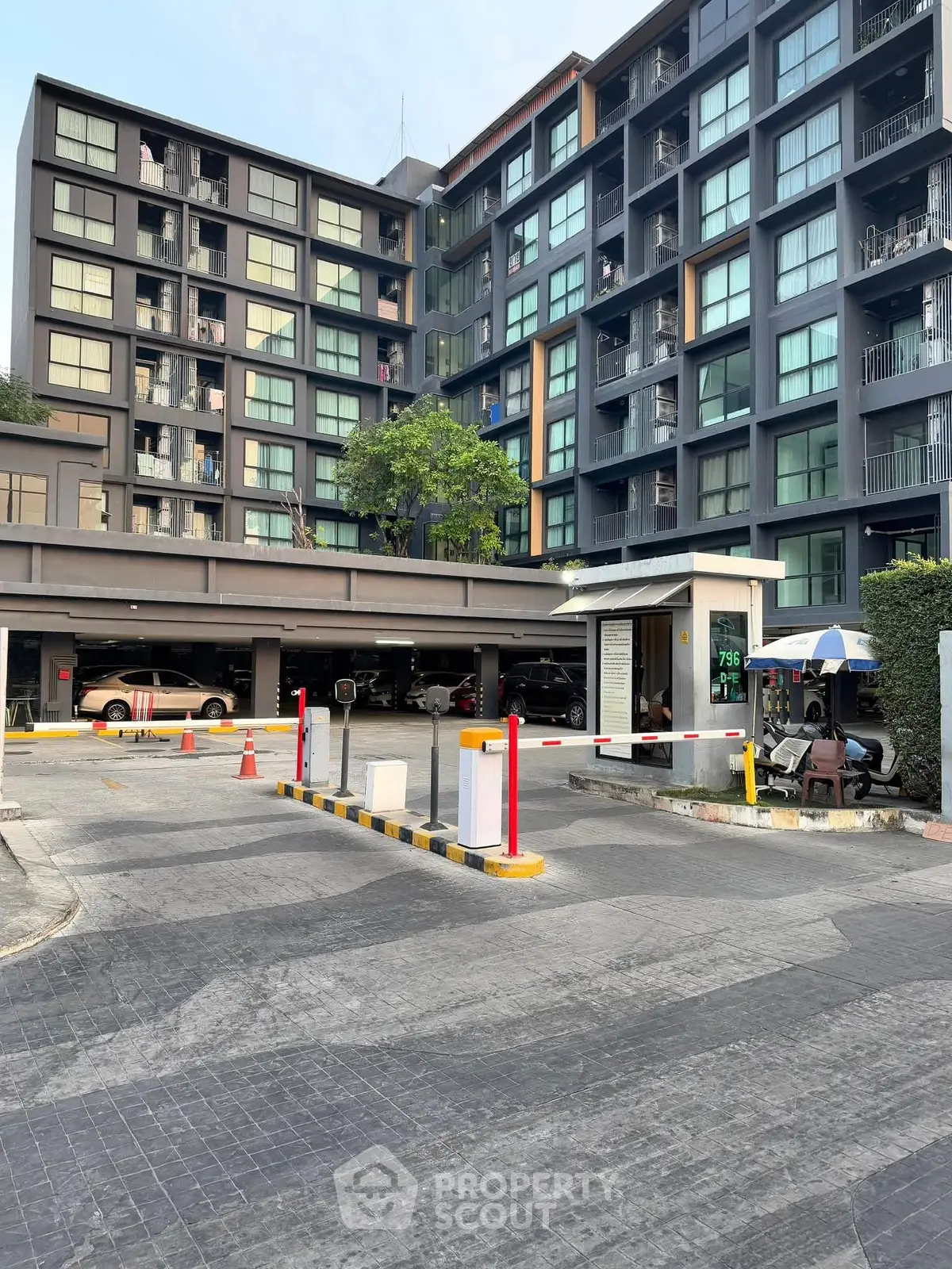 Modern apartment building with parking and secure entrance in urban setting.