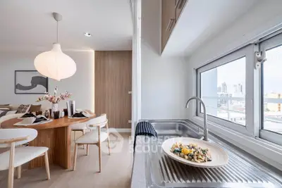 Modern dining area with elegant table setting and city view from kitchen window.