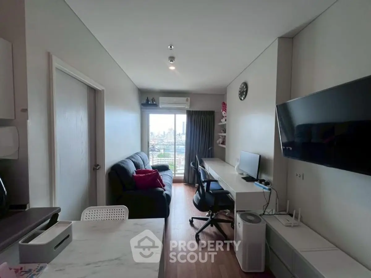 Modern living room with city view, featuring sleek furniture and a large TV, perfect for urban living.
