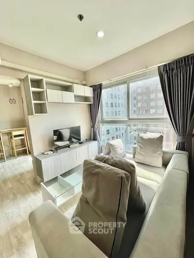 Modern living room with large windows and cozy seating in urban apartment