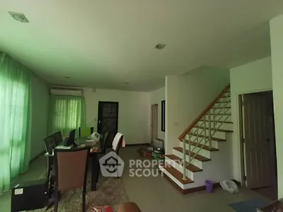 Spacious living room with staircase and natural light, ideal for modern family living.