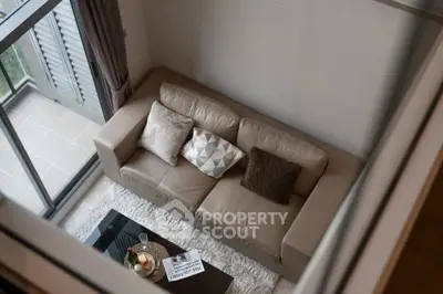 Stylish living room with cozy sofa and balcony view, perfect for relaxation.