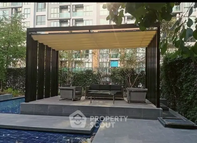Modern outdoor seating area with pergola by a pool in urban setting