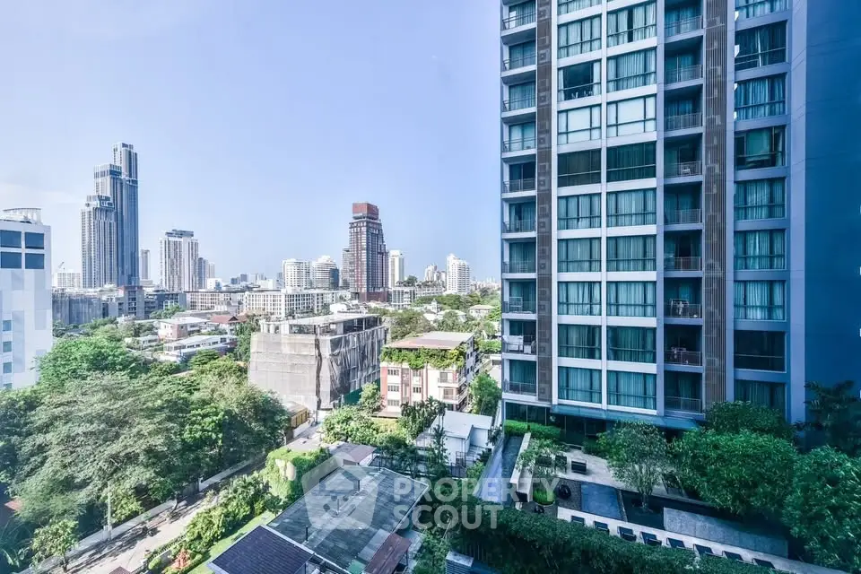 Stunning cityscape view from a modern high-rise apartment with lush greenery and urban skyline.