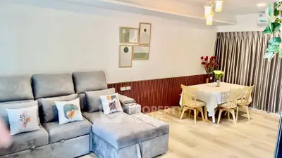 Spacious living room with modern decor and dining area, featuring cozy seating and elegant lighting.