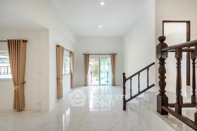 Spacious living room with elegant staircase and large windows in modern home