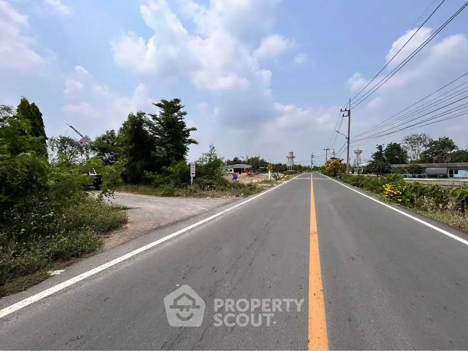 Expansive road view with lush greenery, ideal for real estate development opportunities.