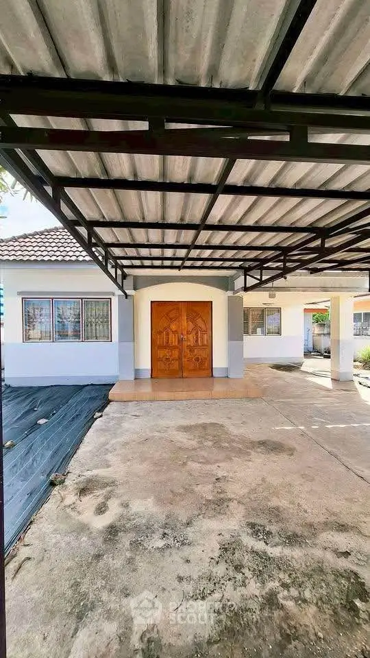 Charming single-story home with covered carport and inviting wooden front door.