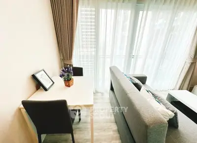 Modern living room with cozy sofa and dining area near large window.