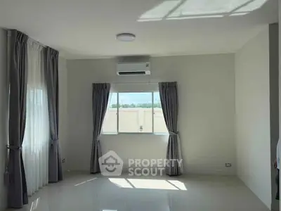 Bright and airy room with large windows and modern air conditioning unit.