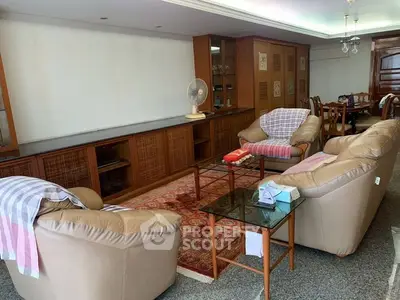 Spacious living room with comfortable seating, elegant wooden cabinetry, and a classic area rug, perfect for family gatherings and relaxation.