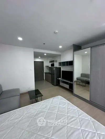 Modern studio apartment with sleek kitchen and cozy living area, perfect for urban living.