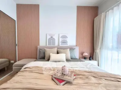 Modern bedroom with stylish decor and natural light, featuring a cozy bed and elegant wall art.