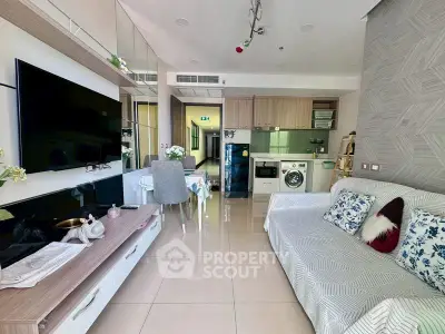 Modern living room with open kitchen, featuring sleek appliances and stylish decor.
