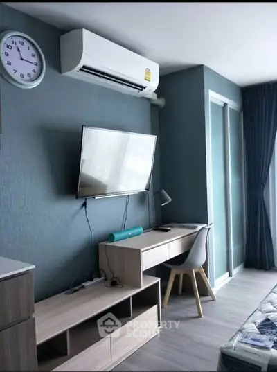 Modern study area with sleek desk, wall-mounted TV, and air conditioning in stylish apartment.