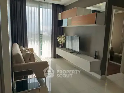 Modern living room with sleek furniture and large window offering natural light