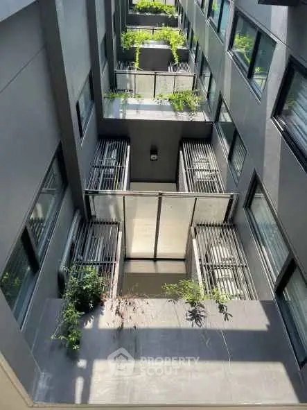 Modern apartment building with multiple balconies and greenery