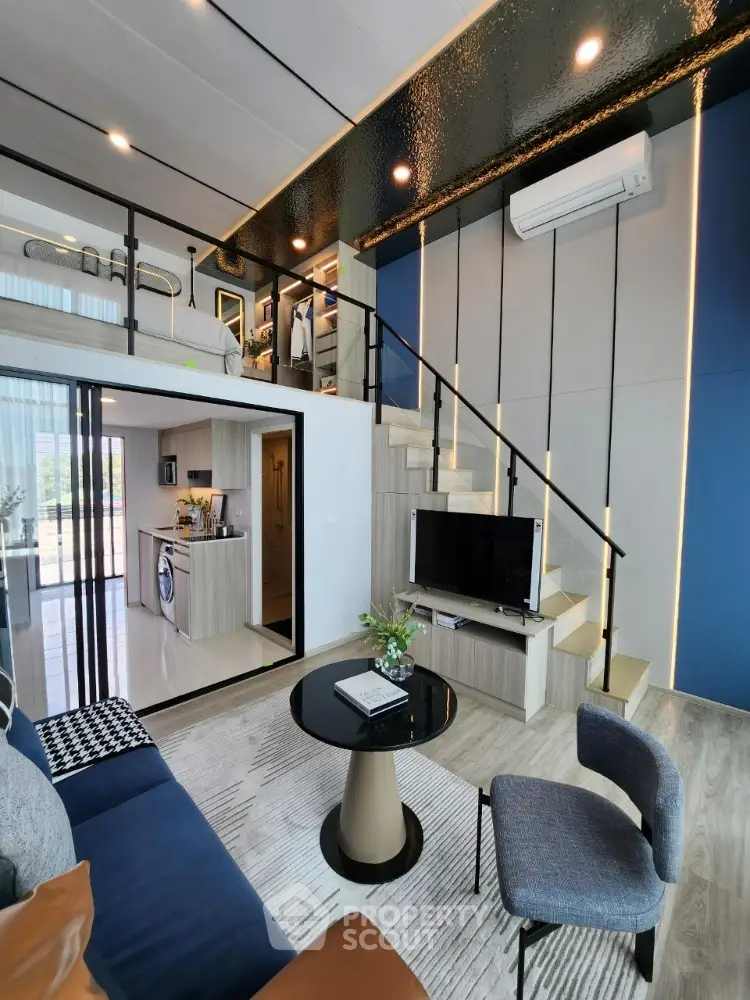 Modern loft-style living room with mezzanine, sleek furniture, and open kitchen layout.
