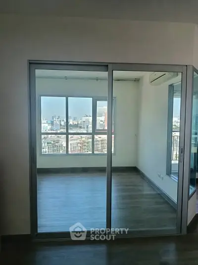 Spacious room with large windows offering a stunning city view, perfect for a modern living space.