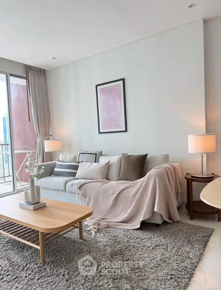 Modern living room with cozy sofa, stylish decor, and balcony view in a high-rise apartment.