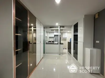 Modern kitchen with sleek cabinetry and glossy finishes in a contemporary apartment.