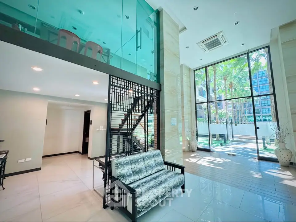 Luxurious modern living room with high ceilings and glass mezzanine in a stylish apartment.