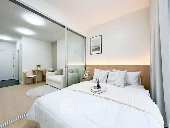 Modern bedroom with sliding glass doors and cozy decor in a stylish apartment.