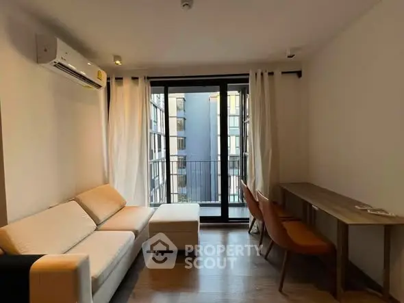 Modern living room with balcony view, featuring sleek furniture and natural light.