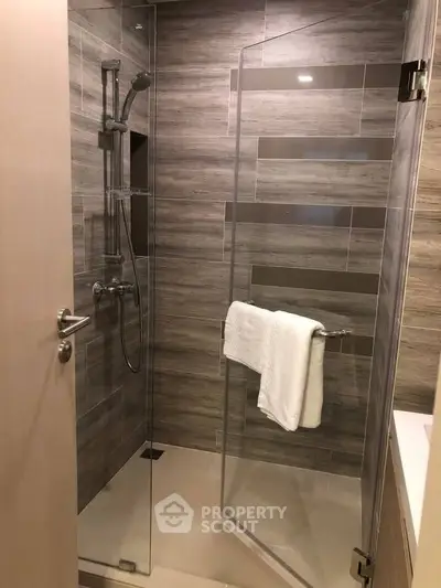Modern bathroom with glass shower and stylish tile design.