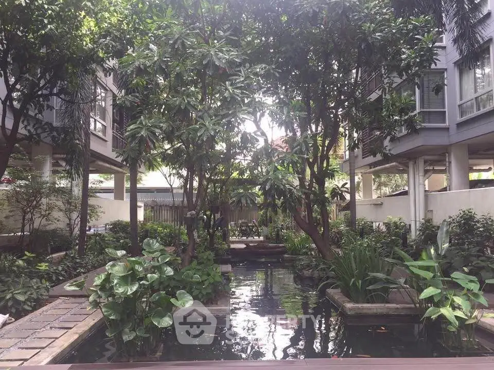 Lush garden with serene pond in modern residential complex