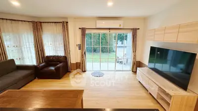 Spacious living room with large windows and modern furnishings, perfect for relaxation and entertainment.