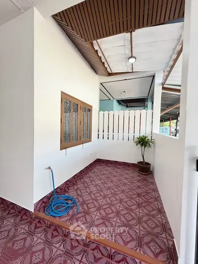 Charming outdoor patio with decorative tiles and potted plant, perfect for relaxation.