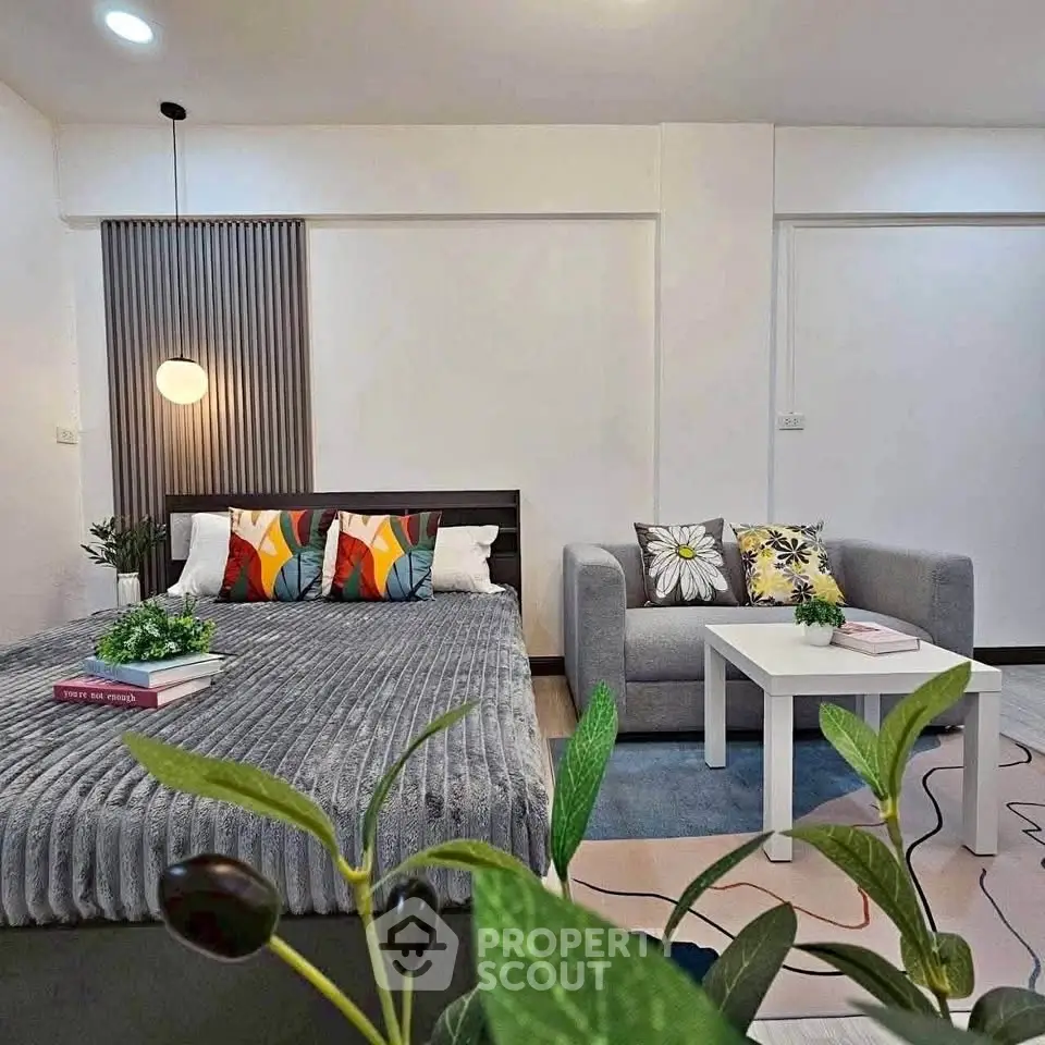 Modern studio apartment with cozy bed and stylish living area, perfect for urban living.