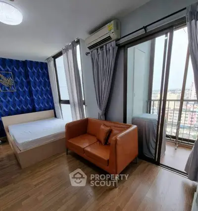 Modern bedroom with balcony and city view, featuring stylish decor and cozy seating area.