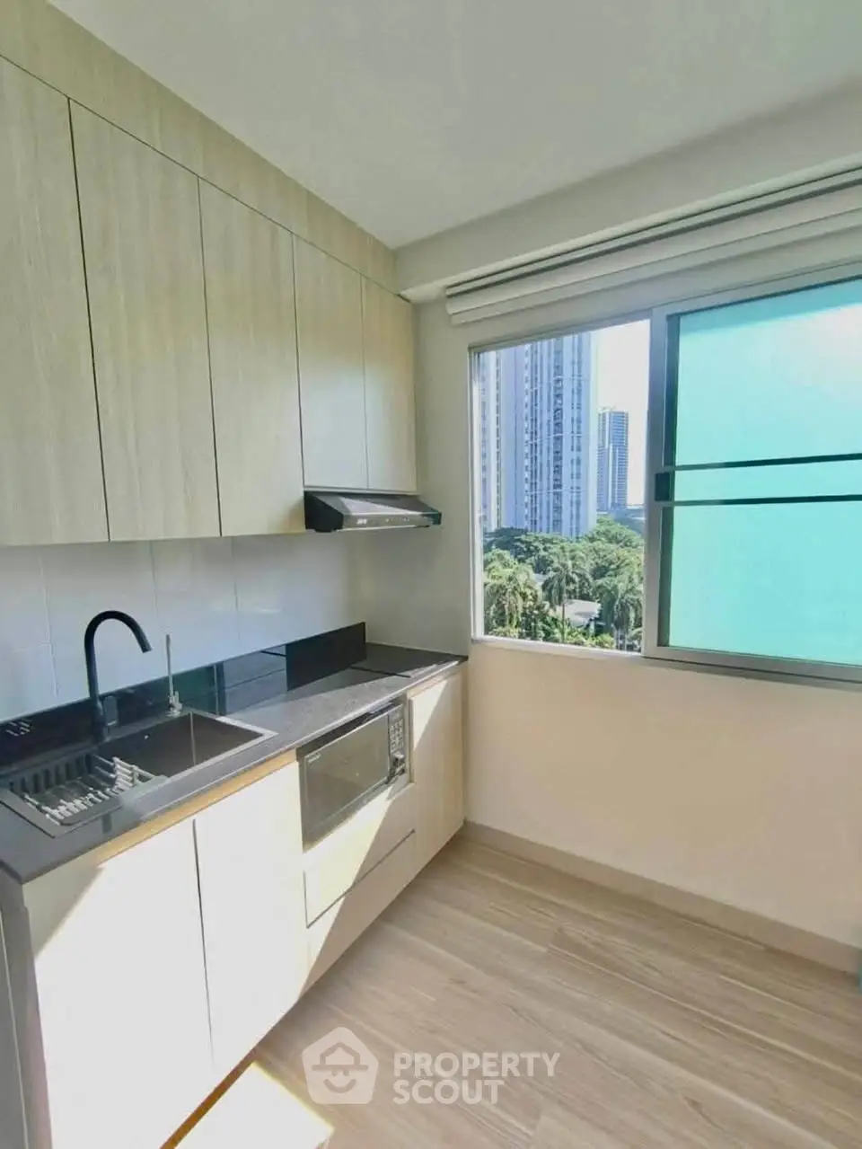 Modern kitchen with sleek cabinetry and city view window