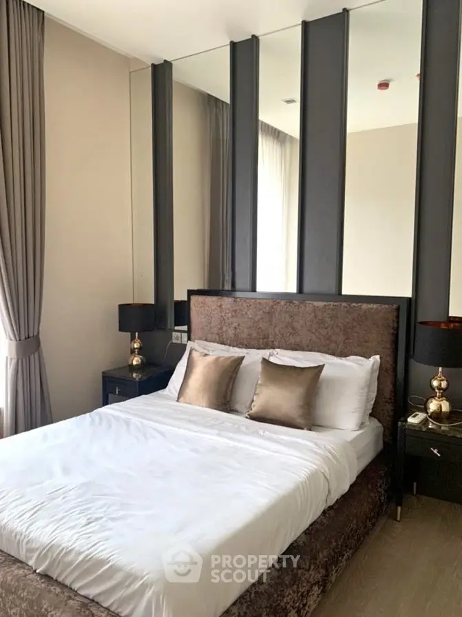 Luxurious bedroom with elegant decor and plush bedding in modern apartment.