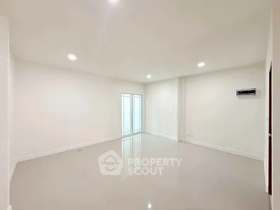 Spacious empty room with glossy floors and bright lighting, perfect for customization.
