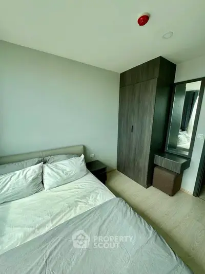 Modern bedroom with sleek wardrobe and cozy bed in a stylish apartment.