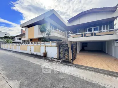 Modern residential building with unique architecture and spacious driveway in a serene neighborhood.
