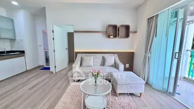 Modern living room with cozy sofa, stylish decor, and open kitchen layout in a bright apartment.