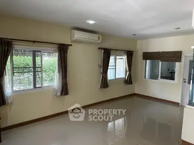 Spacious unfurnished living room with large windows and air conditioning