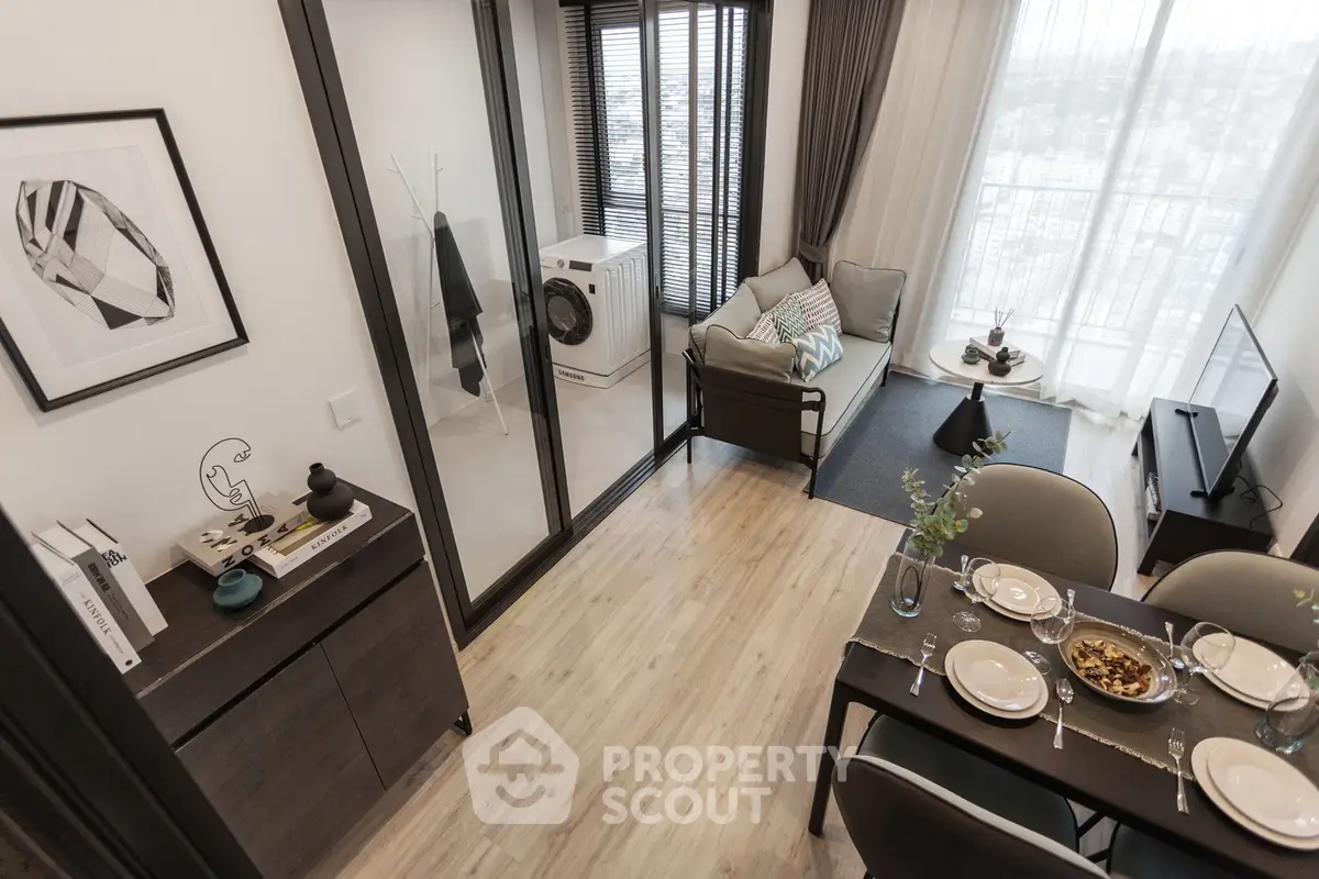 Modern living room with dining area and large windows offering city views.
