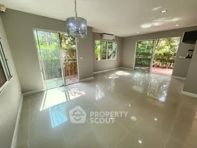 Spacious living room with large windows and garden view, perfect for natural light lovers.