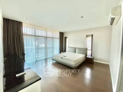 Spacious modern bedroom with large windows and sleek furnishings