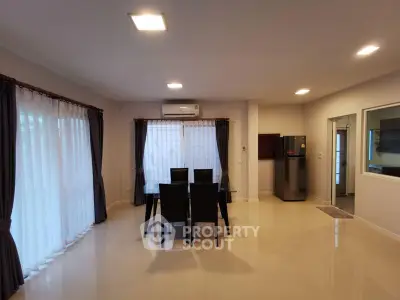 Spacious dining area with modern decor and large windows in a contemporary home.