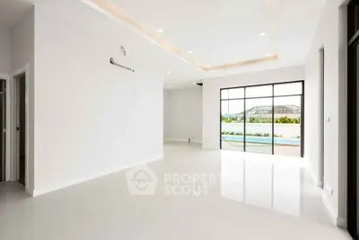 Spacious modern living room with large windows and pool view