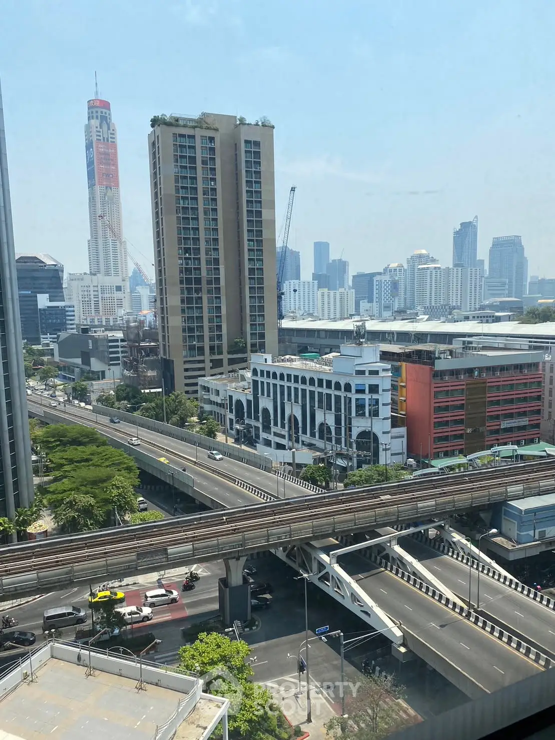 Stunning cityscape view from high-rise building with modern architecture and clear blue sky.