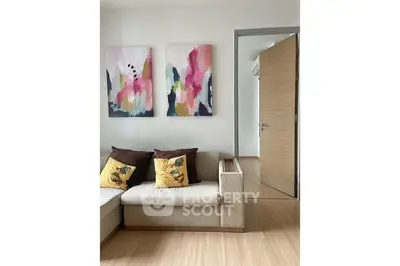 Modern living room with stylish sofa and colorful abstract art on the wall.