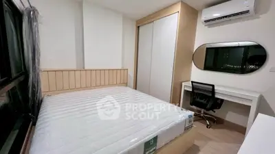 Modern bedroom with built-in wardrobe and study desk, featuring air conditioning and sleek design.