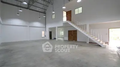 Spacious industrial-style interior with high ceilings and mezzanine level.